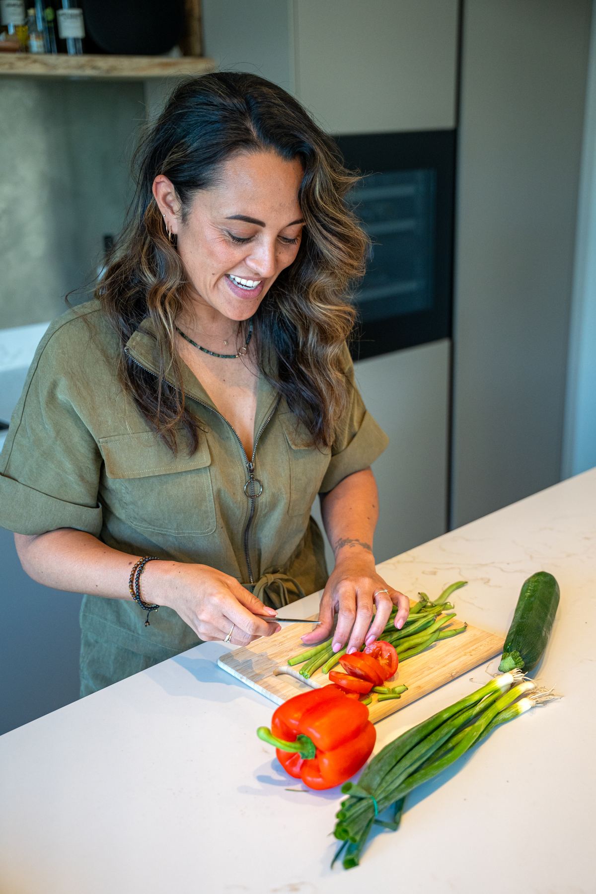 Romy snijdt paprika en lente-ui op een keukenblad
