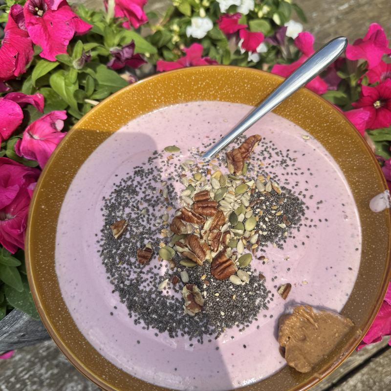 Pink yoghurt bowl with chia seeds, pecans and seeds