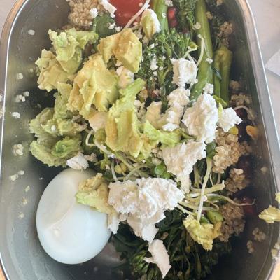 Bowl met quinoa, broccolini, avocado, feta en een gekookt ei