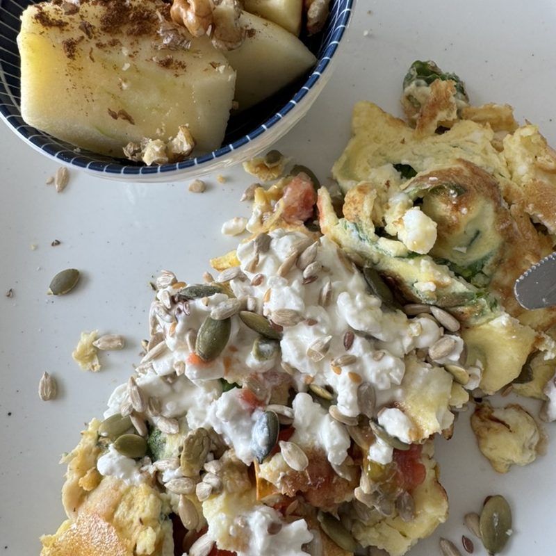 Omelette with vegetables, cottage cheese and seeds, with a bowl of apple and walnuts
