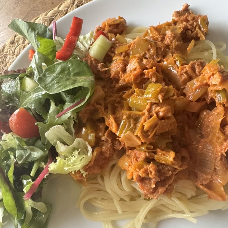 Spaghetti with chicken in tomato sauce and a fresh salad