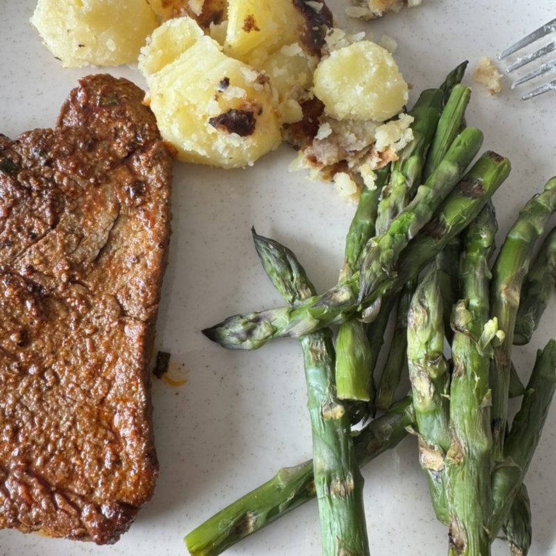 Roast potatoes with green asparagus and meat